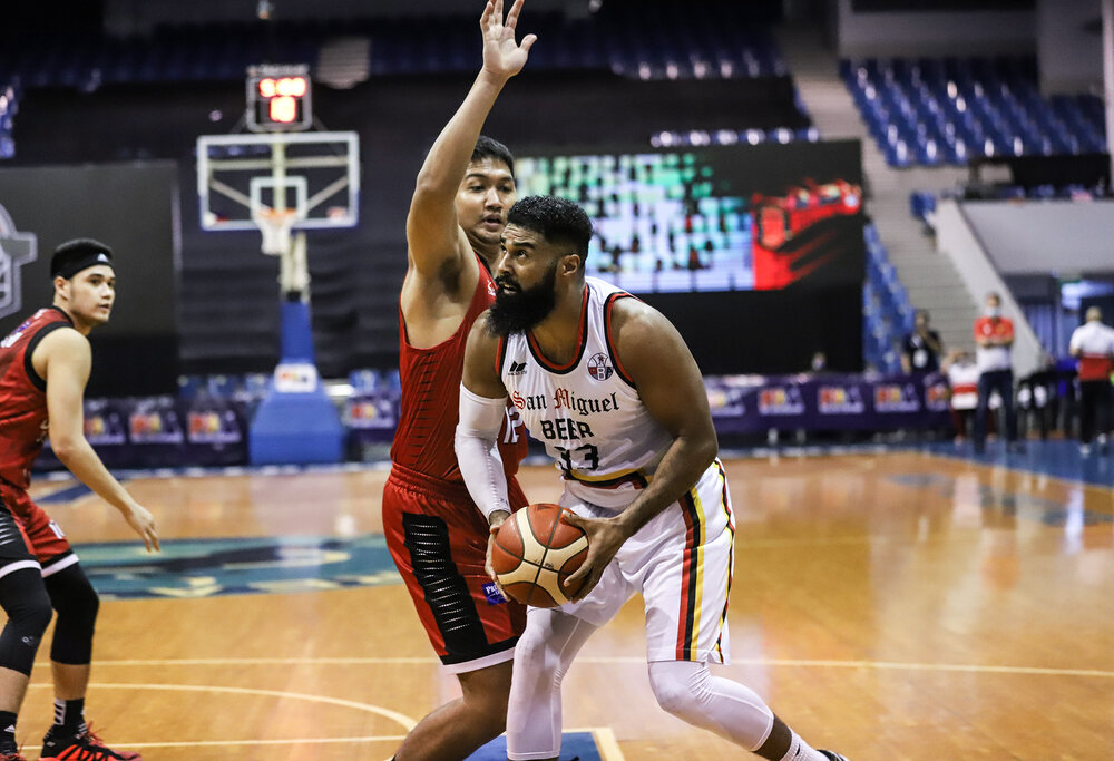 San Miguel’s Mo Tautuaa makes a move against Prince Caperal of Ginebra. (Photo from PBA)