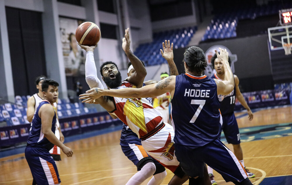 San Miguel’s Mo Tautuaa gets creative against Cliff Hodge of Meralco. (Photo from PBA)