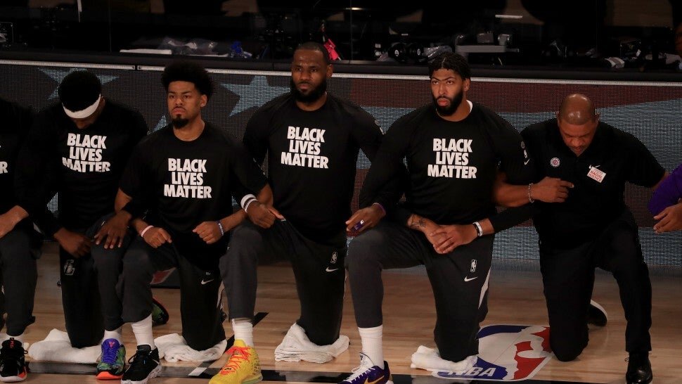Lakers stars’ LeBron James, Anthony Davis and Clippers’ head coach Doc Rivers kneel during the national anthem. (Photo by Mike Ehrmann/Getty Images)